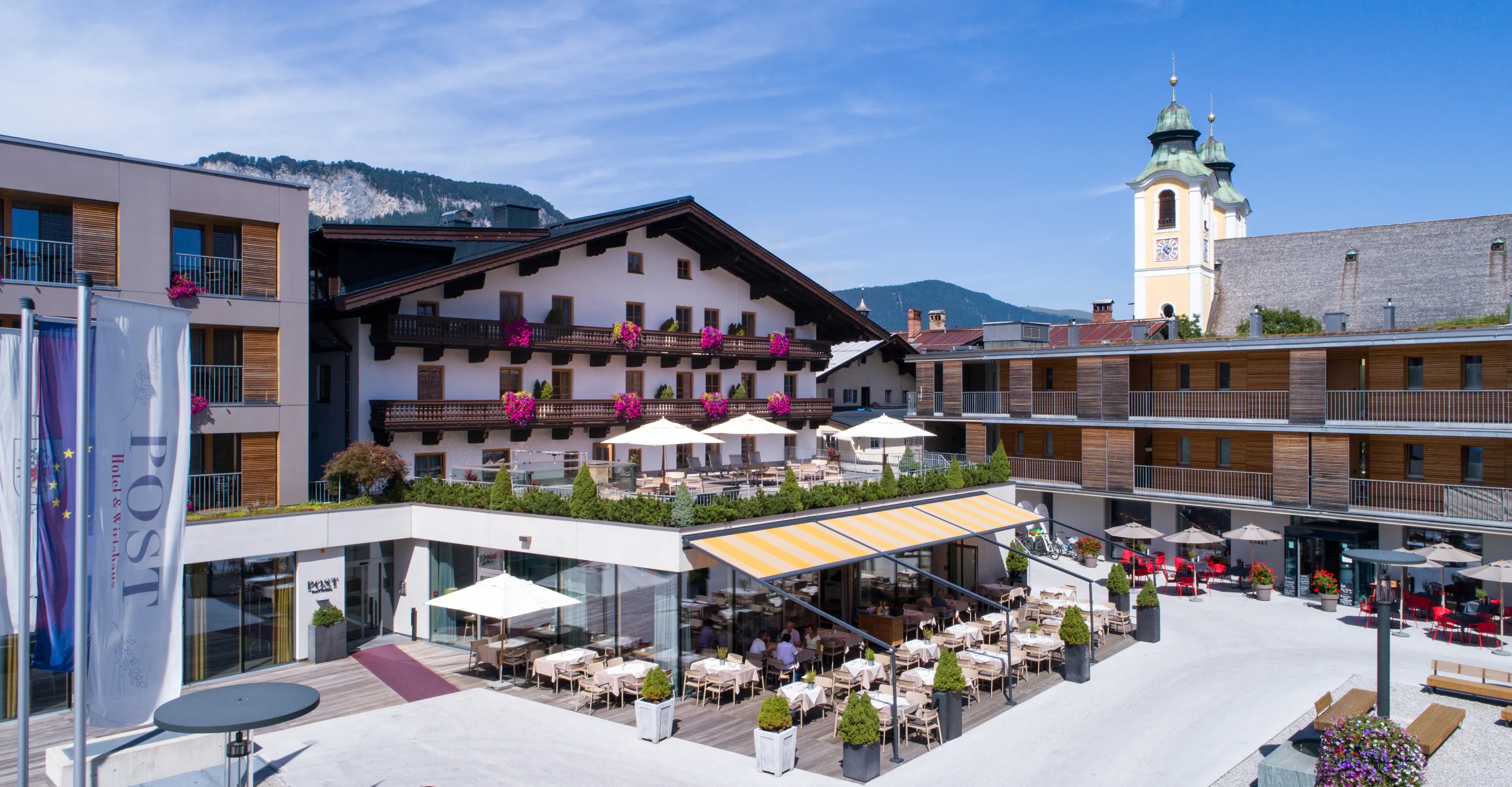 Malersicher Blick auf den Hotelgarten mit Bergen im Hintergrund