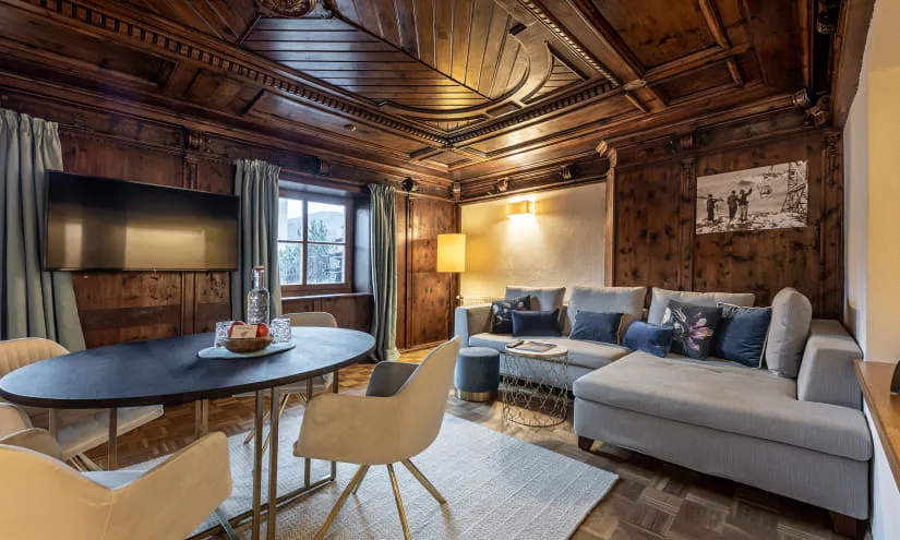 Wohnraum mit Holzdecke, Sofa, Tisch und Fernseher