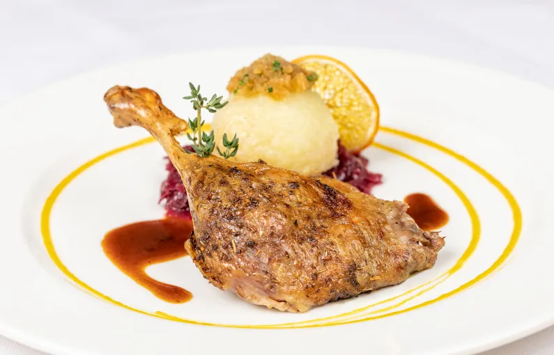Gericht mit Hähnchenschenkel, püriertem Gemüse, Sauce und Beilage