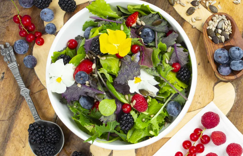 Bunte Salat mit Beeren und essbaren Blumen