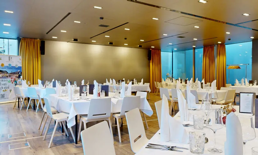 leeres Restaurantsetup mit Tischen und weißen Tischdecken