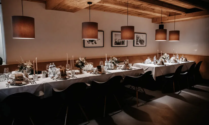 elegant gedeckter langer Esstisch mit Kerzen und Blumendekorationen
