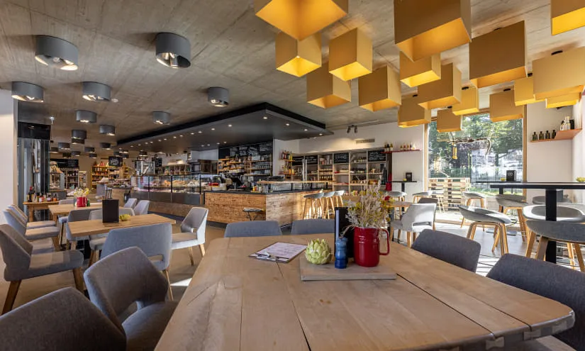 Heller Innenraum eines Cafés mit Holzregalen und modernen Leuchten