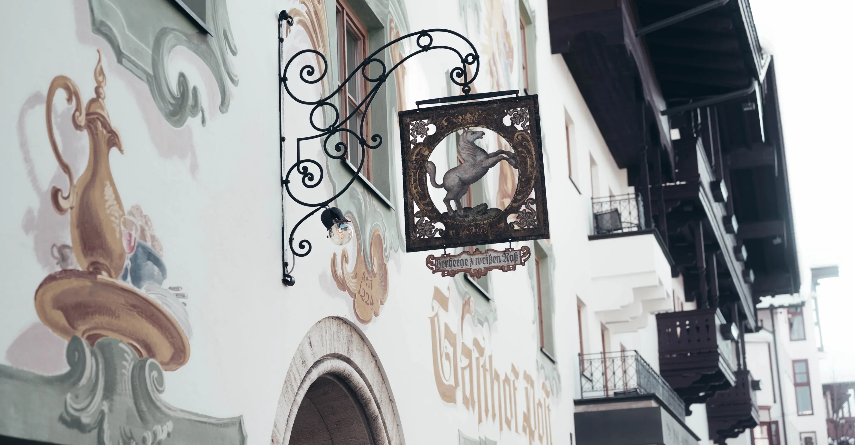 Schmiedeeiserner Schild mit Tiermotiv an einem Gebäude, dekorative Wandmalerei